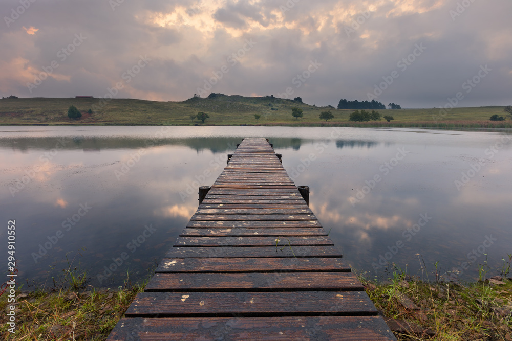 Landscape of a jetty on a dam with dramatic clouds of rain storm