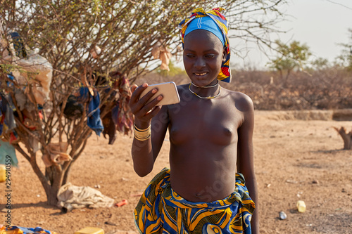 Young Mucubal woman checking her smartphone, Tchitundo Hulo, Virei, Angola photo