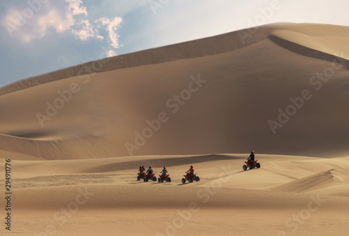 Driving off-road with quad bike or ATV vehicles. Namib sand desert on the background