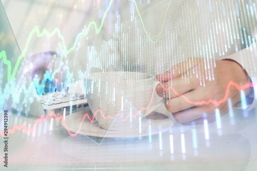 Double exposure of graph with man typing on computer in office on background. Concept of hard work. Double exposure of graph with man typing on computer in office on background. Concept of hard work.