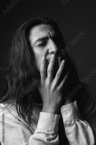 Portrait of depressed young man with long hair. Black and white