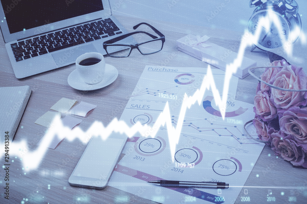 Stock market chart hologram drawn on personal computer background. Multi exposure. Concept of investment. Stock market chart hologram drawn on personal computer background. Multi exposure. Concept of investment.