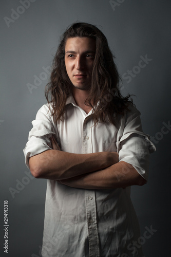 Serious young man on gray background. Studio portrait