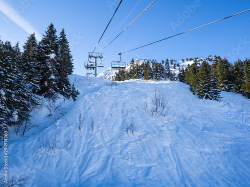 France. january, 2018: Ski lift and ski slope with skiers under it on sunny winter day with blue sky. Alpine resort Meribel, Europe © ikmerc