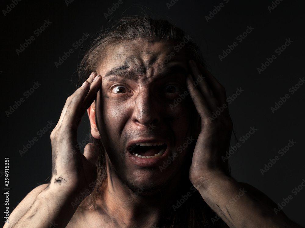 Portrait of a screaming young man in soot. Portrait of a screaming young man in soot.
