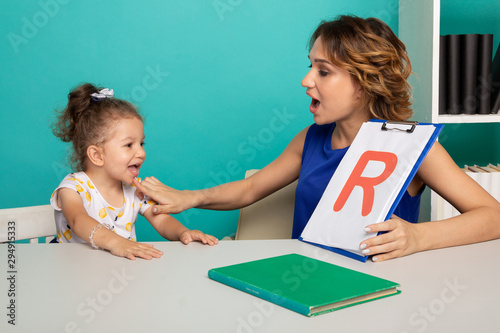 фотографія Female therapist working with kid with problem in pronunciation in the white cab