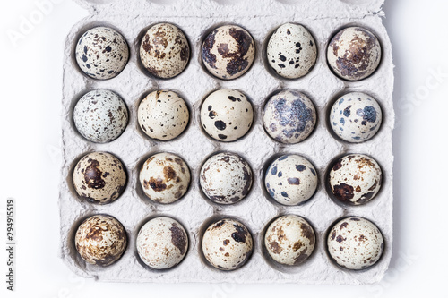 cardboard box with quail eggs on a white table