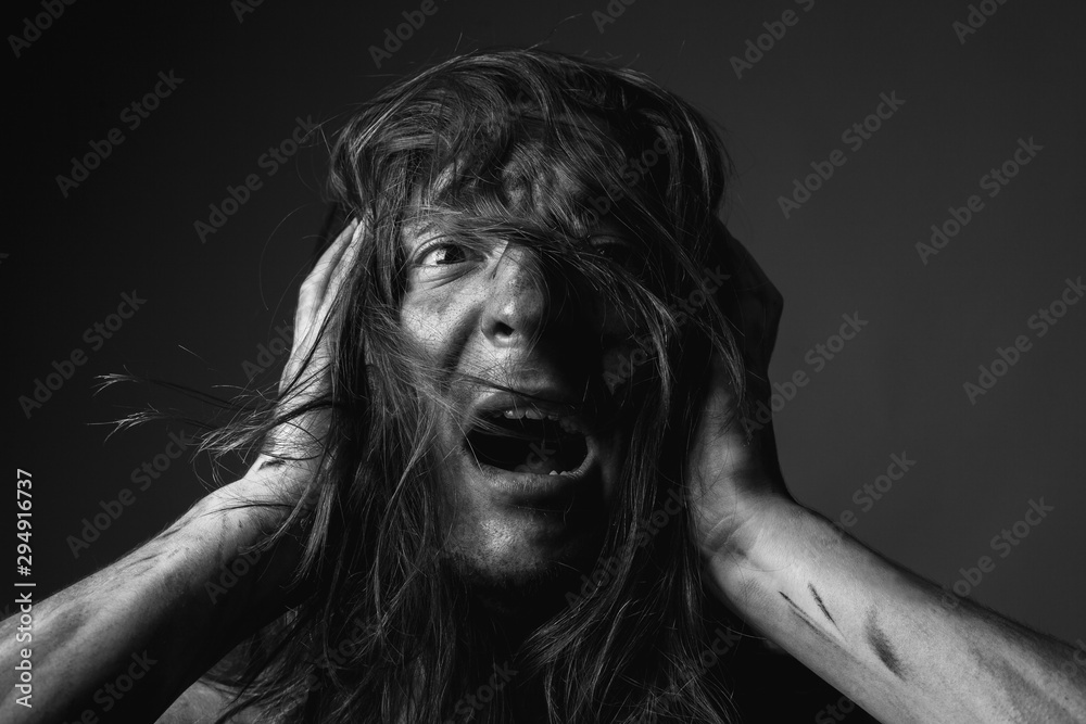 Portrait of scared young man with long hair in soot. Portrait of scared young man with long hair in soot.
