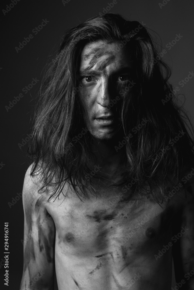 Portrait of young man with long hair in soot. Black and white Portrait of young man with long hair in soot. Black and white