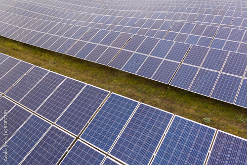 Renewable electricity, unmanned flight over a solar power plant located in the field.