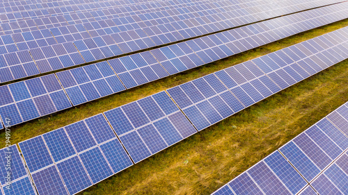 Renewable electricity, unmanned flight over a solar power plant located in the field.