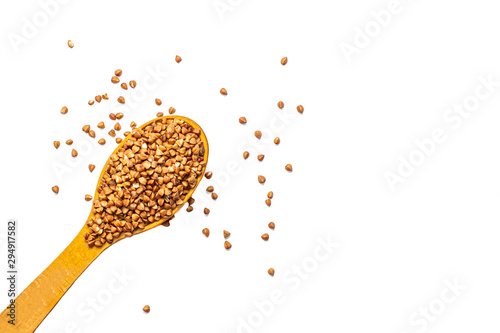 Buckwheat groats in a wooden spoon on a white background.