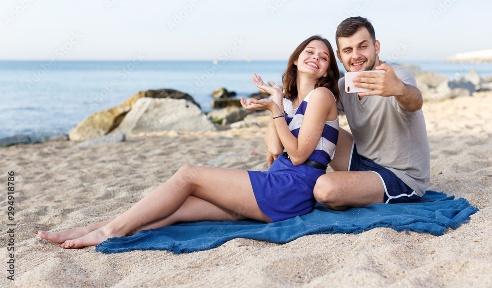 Fototapeta premium Happy loving couple resting and taking selfie