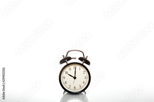 black vintage alarm clock, the time is 10 o'clock, isolated on white background