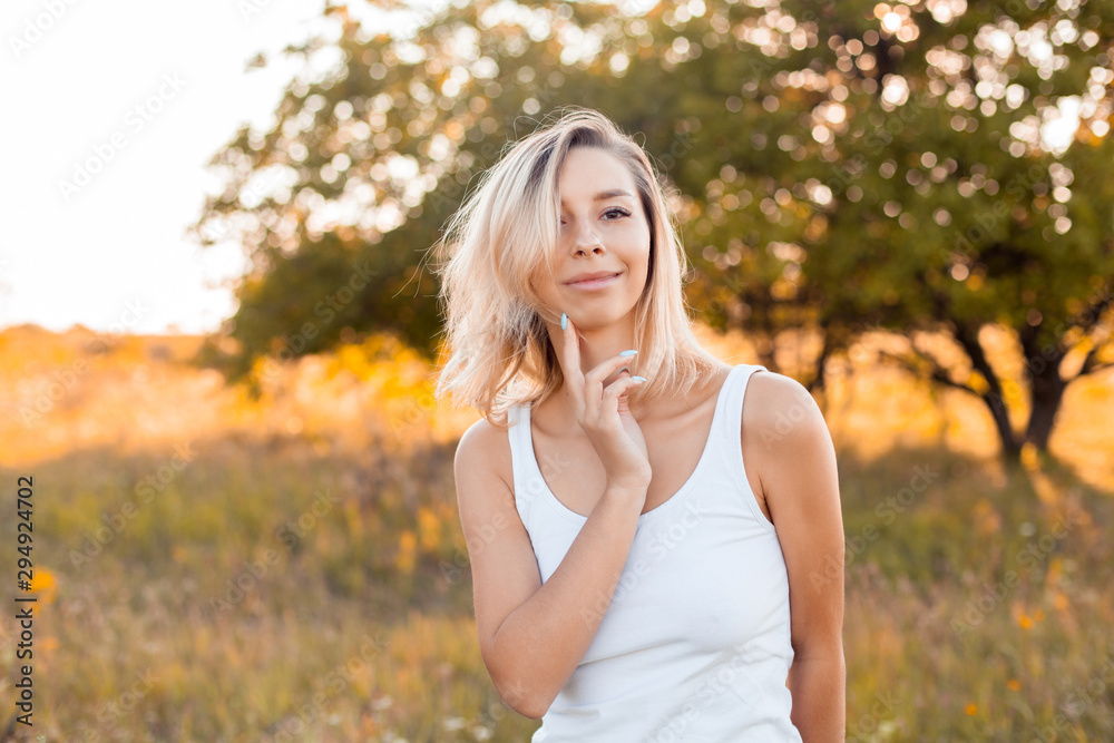 Young happy woman walking outdoors at sunset Young happy woman walking outdoors at sunset