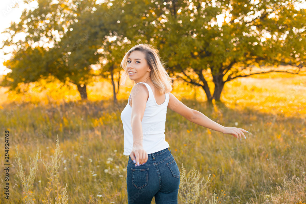 Beautiful young blonde woman having fun outdoors. Back Beautiful young blonde woman having fun outdoors. Back