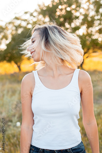 Happy woman in white shirt walking outdoors under daylight