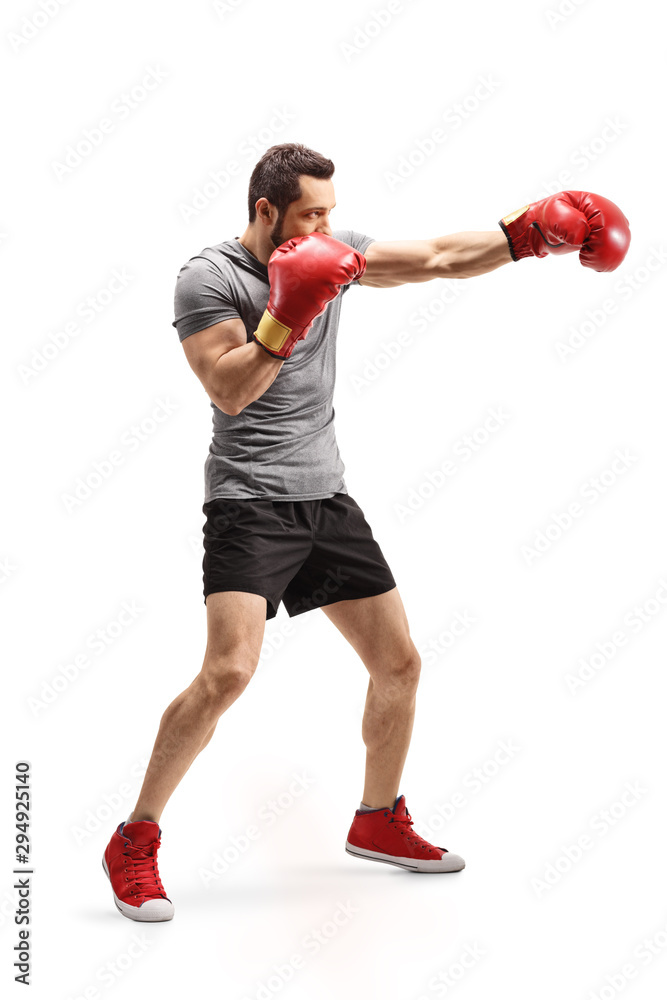 Strong young man punching with boxing gloves Strong young man punching with boxing gloves