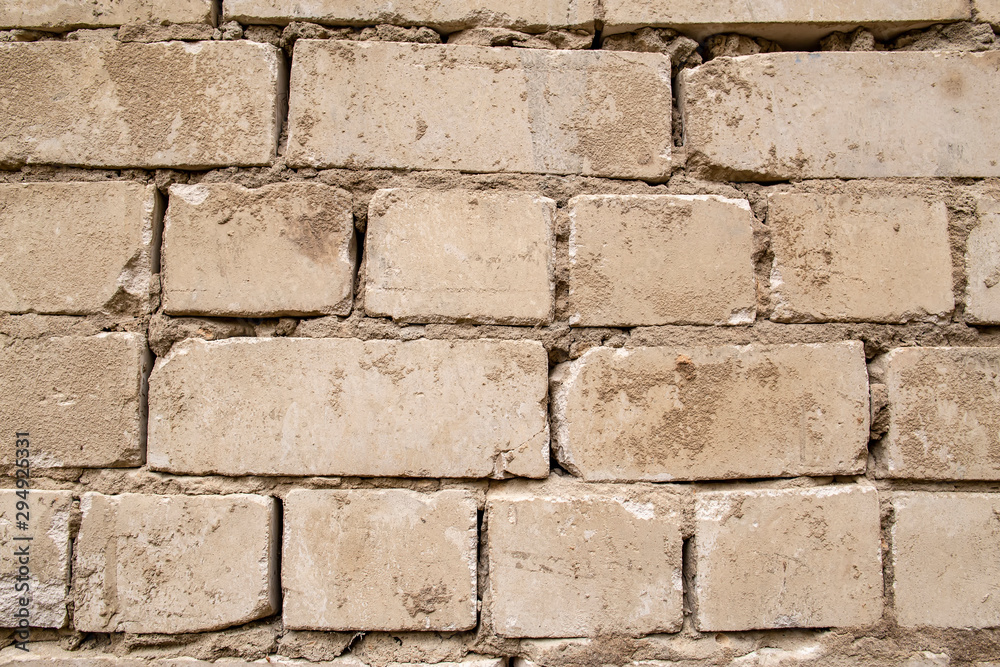 Old, beginning to collapse, carelessly laid brickwork, made of white brick. Background. Old, beginning to collapse, carelessly laid brickwork, made of white brick. Background.