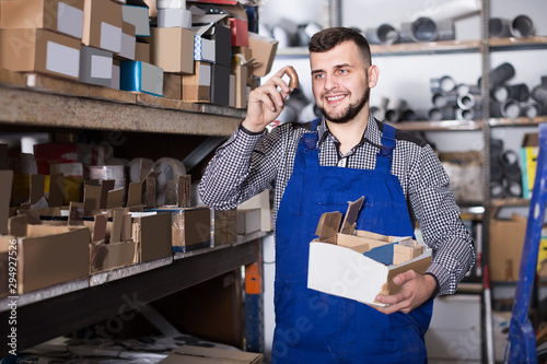 Tableau sur toile Attractive male worker sorting sanitary engineering details