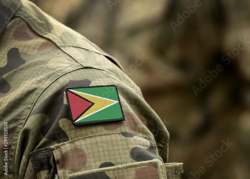 Flag of Guyana on on military uniform. Army, troops, soldier (collage).