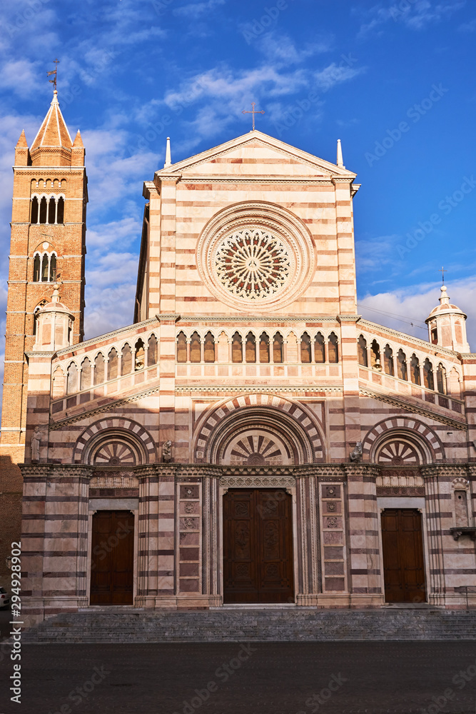 Facade of a historic church with belfry in the city of Grosseto, Italy.