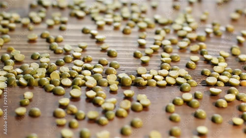Green split peas adding to wooden board Green split peas adding to wooden board