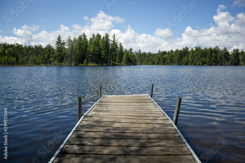 Small Wooden Dock On Beautiful Blue Pond In The Forest