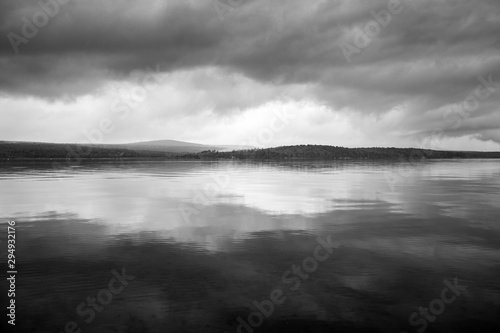 Dark, Foreboding Storm Clouds Over A Gloomy Gray Lake Landscape