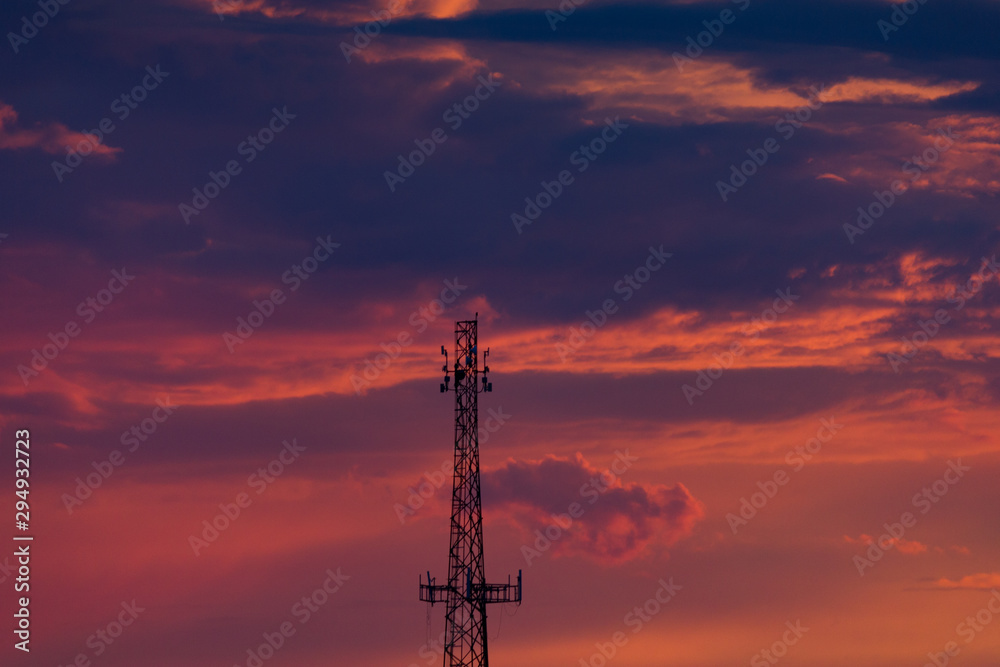 Cell Phone Tower Silhouetted Against Orange and Purple Clouds at Sunset Cell Phone Tower Silhouetted Against Orange and Purple Clouds at Sunset
