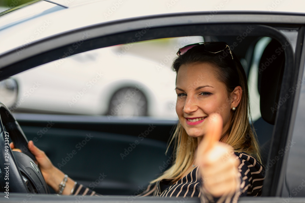 Satisfied girl gesturing thumbs up sitting inside a car