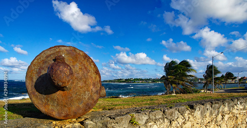An old rusty cannon on the edge of coastline in Le Moule town in Guadeloupe, Grande-Terre island, french West Indies photo