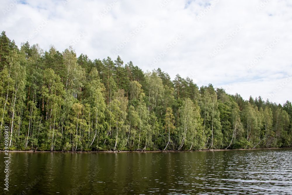 Lake Hallanlahti summer view with reflection of clouds on water .