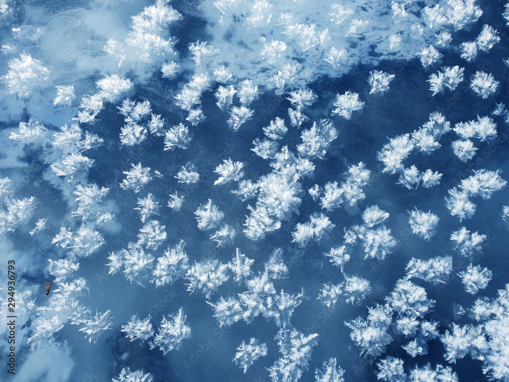 Snowflakes as a snow butterflies over frozen icy river. Frosty nature background. Snowflakes as a snow butterflies over frozen icy river. Frosty nature background.