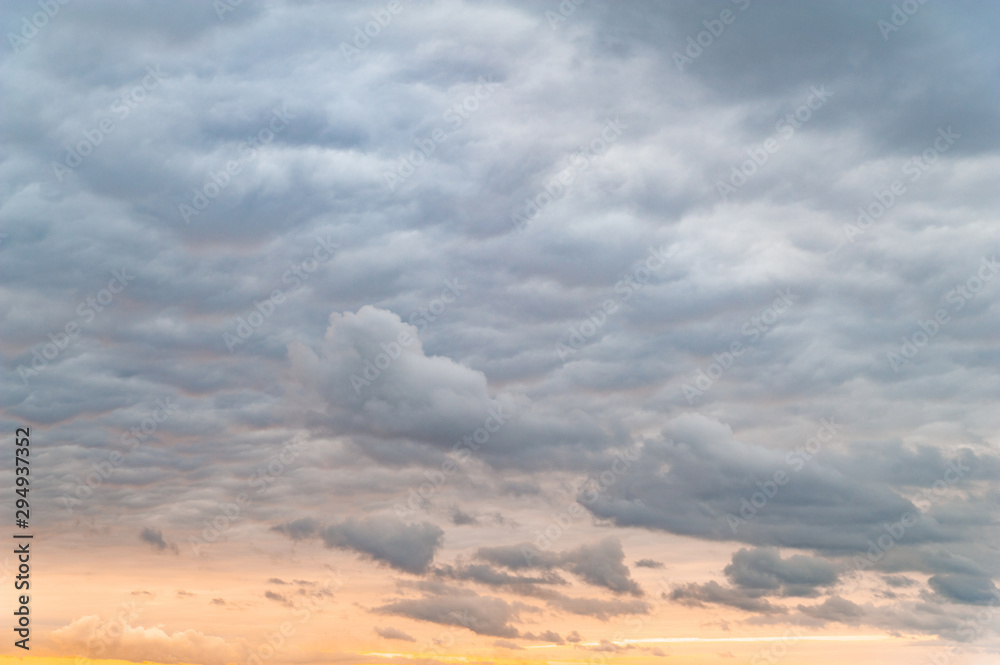Obraz premium Dark clouds. Sky with leaden gray clouds in the evening at orange-pink sunset.