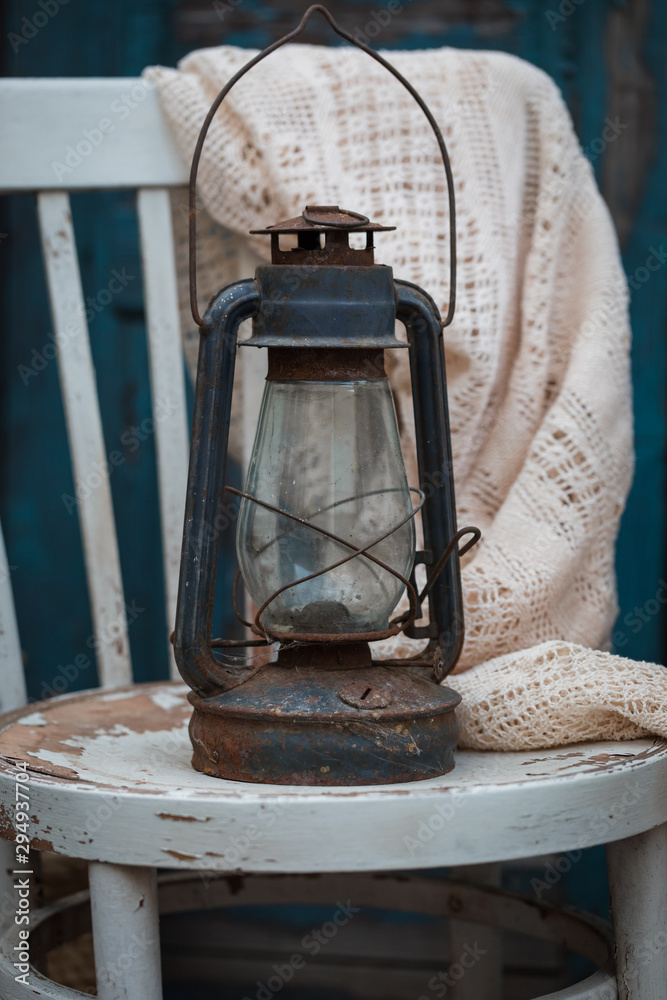 Antique oil lamp on the rustic white chair