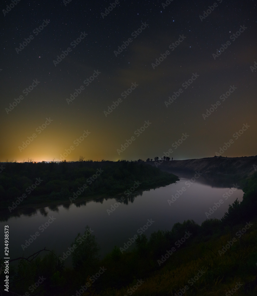 Stars in the night sky over the river. Photographed with a long exposure.