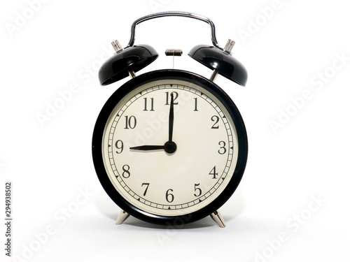 Old-style alarm clock, black and white, it's nine o'clock.