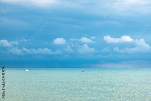 Fototapeta Naklejka Na Ścianę i Meble -  Blue sea and several boats on a cloudy day