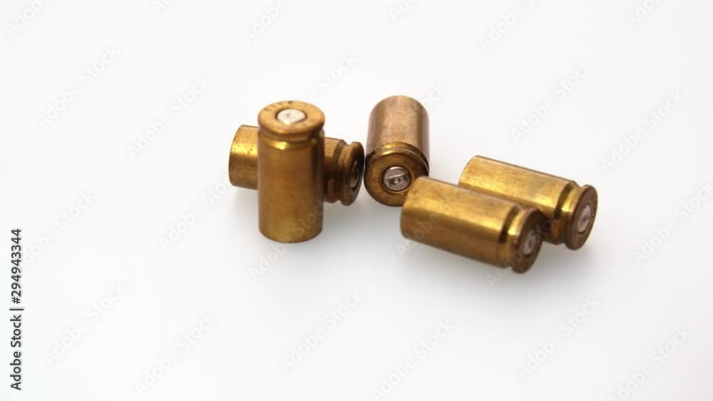 Extreme close up shot of rotating bullet shells on white background. Taking justice in own hands concept Extreme close up shot of rotating bullet shells on white background. Taking justice in own hands concept