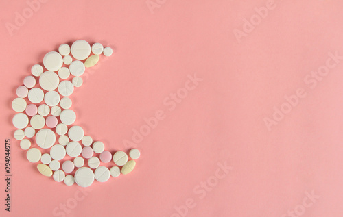 Foto Sleeping pills of different shapes on a pink background