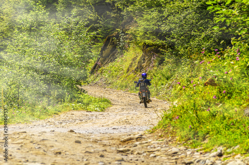 Ukraine  Carpathians. Biker rides on a dirt mountain road.