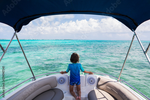 Rear view of boy standing on boat