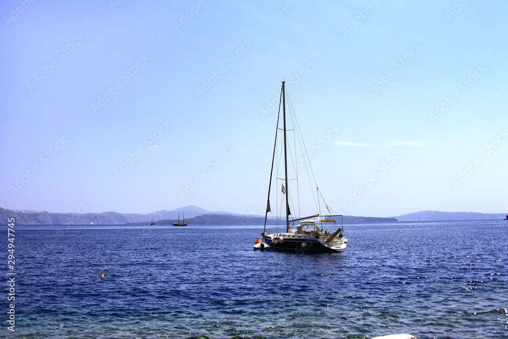 A boat moored in the transparent waters of the Greek island of Thirassia