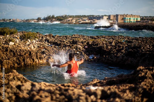 A young man jumps into the water at a beach in Gibara, a municipality in eastern Cuba. photo