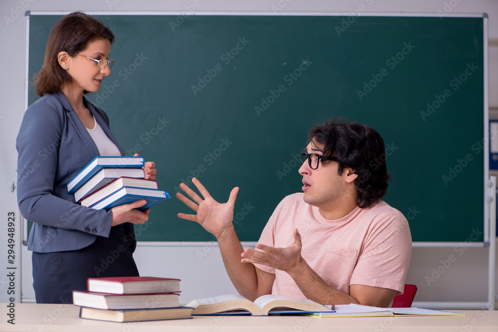 Old female teacher and male student in the classroom Old female teacher and male student in the classroom