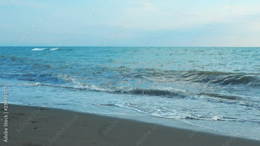 Sea wave rolls ashore close-up, low angle view, slow motion footage sunrise or blue hour time Sea wave rolls ashore close-up, low angle view, slow motion footage sunrise or blue hour time