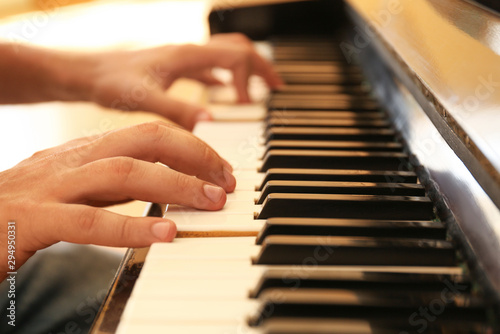 Man playing piano indoors, closeup. Music lesson
