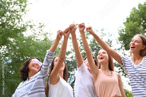 Happy women raising hands outdoors. Girl power concept