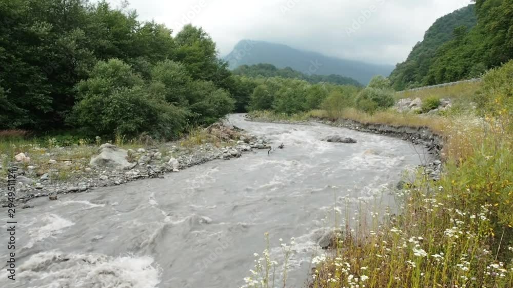Beautiful Natural Torrent of a Stormy Mountain River. Flash Flood Muddy River. Rushes River Raging Fast Flowing Water. Natural Disasters Stormy Brown Turbid Water Flow Beautiful Natural Torrent of a Stormy Mountain River. Flash Flood Muddy River. Rushes River Raging Fast Flowing Water. Natural Disasters Stormy Brown Turbid Water Flow
